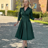 Butelkowa zieleń, ciemnozielona sukienka retro midi z lat 50. z rozkloszowanym dołem, rękawami 3/4 i kratką tartan na kołnierzu. Elegancka sukienka z dopasowaną talią, idealna na jesień i zimę. Styl vintage, klasyczny fason, idealny na specjalne okazje.