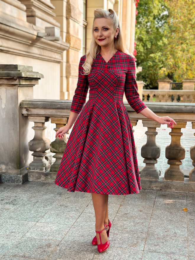 Czerwona sukienka w szkocką kratę z flaneli bawełnianej, retro styl lat 50., rękawy 3/4, dekolt w kształcie litery V, rozkloszowana spódnica, wiskozowa podszewka, kieszenie w szwach bocznych.