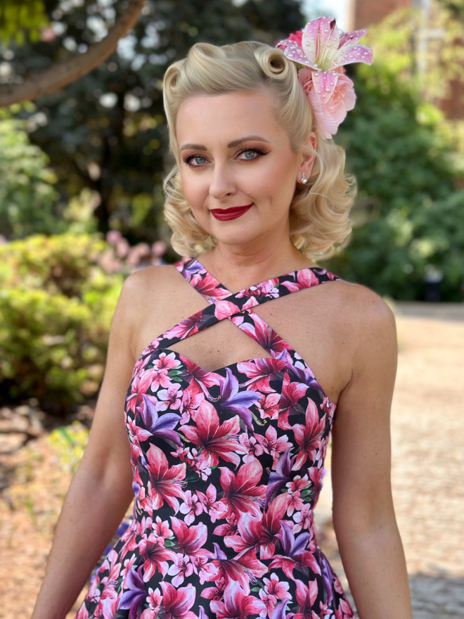 Sukienka w kwiaty z dekoltem w kształcie serca i ozdobnym kwiatem we włosach